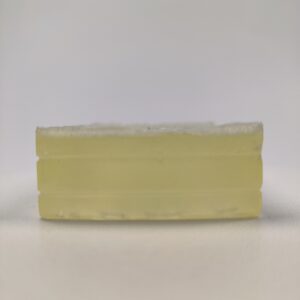 Trzy bloki przezroczystej, lekko żółtawej bazy mydlanej ułożone w stos na białym tle