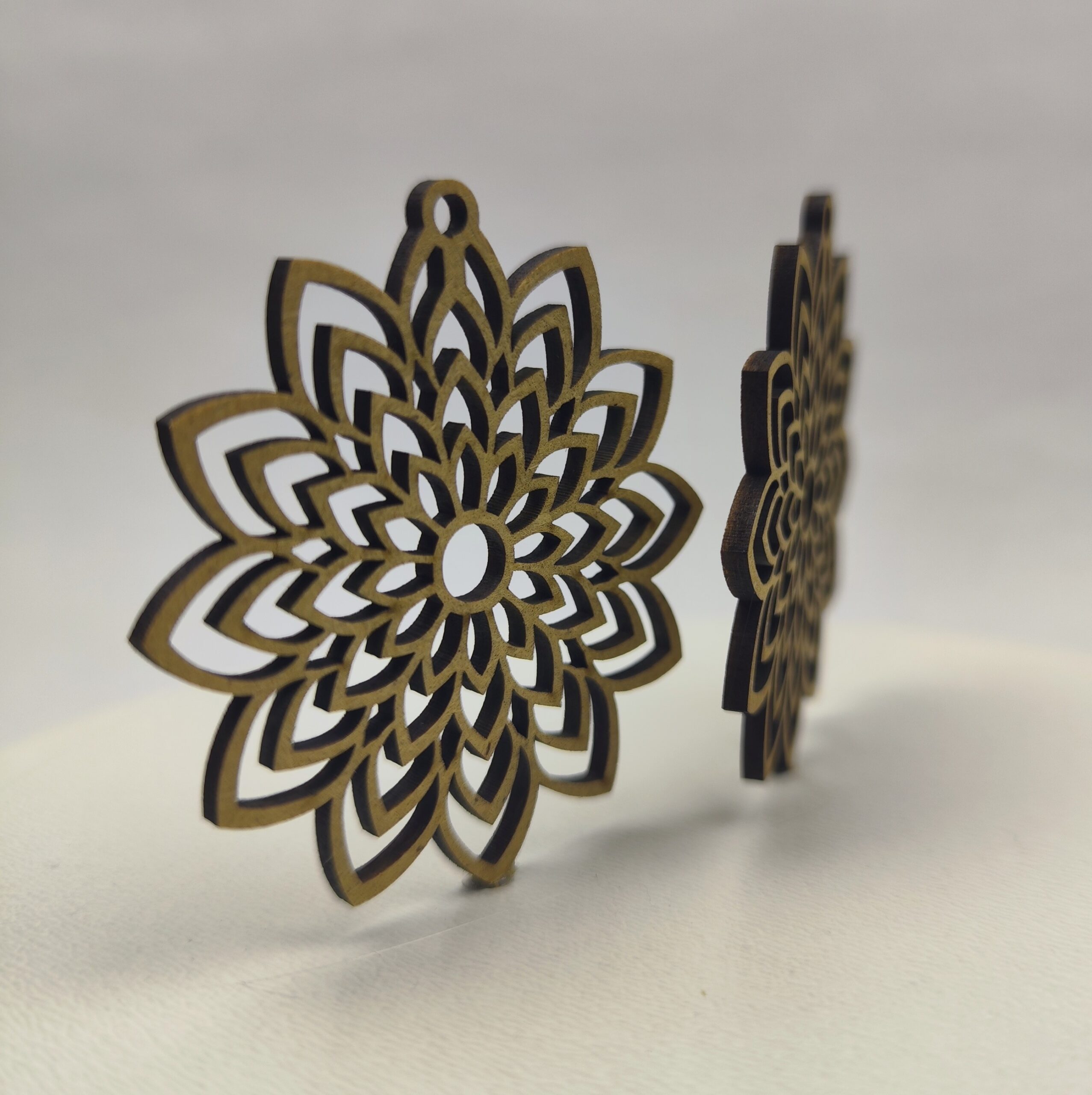 Drewniana baza do kolczyków w kształcie misternej rozety, ażurowy wzór mandali.