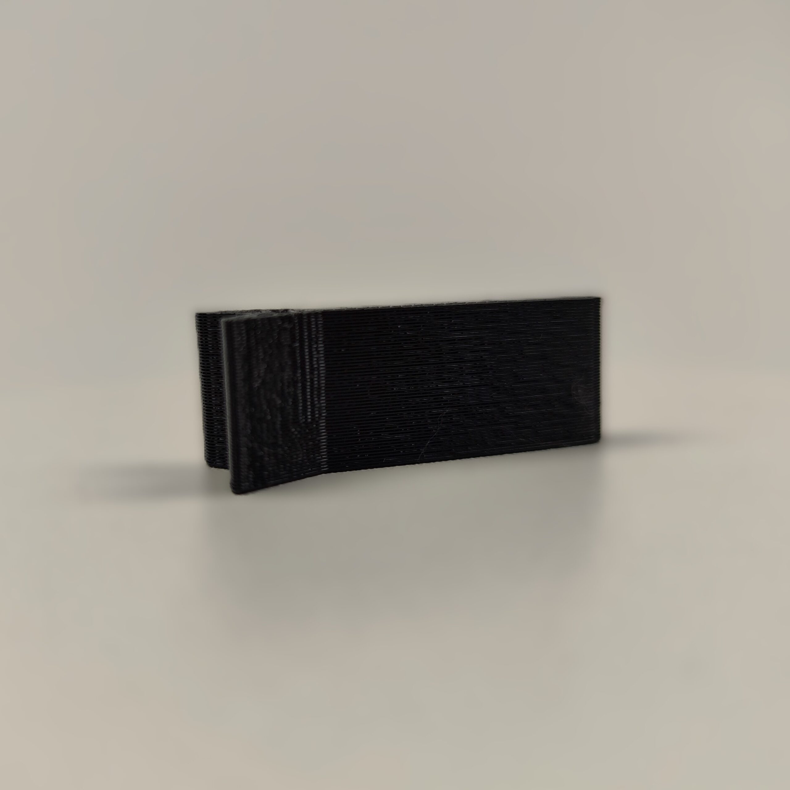 Magnetyczny uchwyt do gwoździ wykonany w technologii druku 3D z czarnego tworzywa, ułatwiający precyzyjne wbicie gwoździa bez narażania palców. Akcesorium ma formę płaskiego elementu z widocznym okrągłym zagłębieniem na magnes i szczeliną stabilizującą gwóźdź