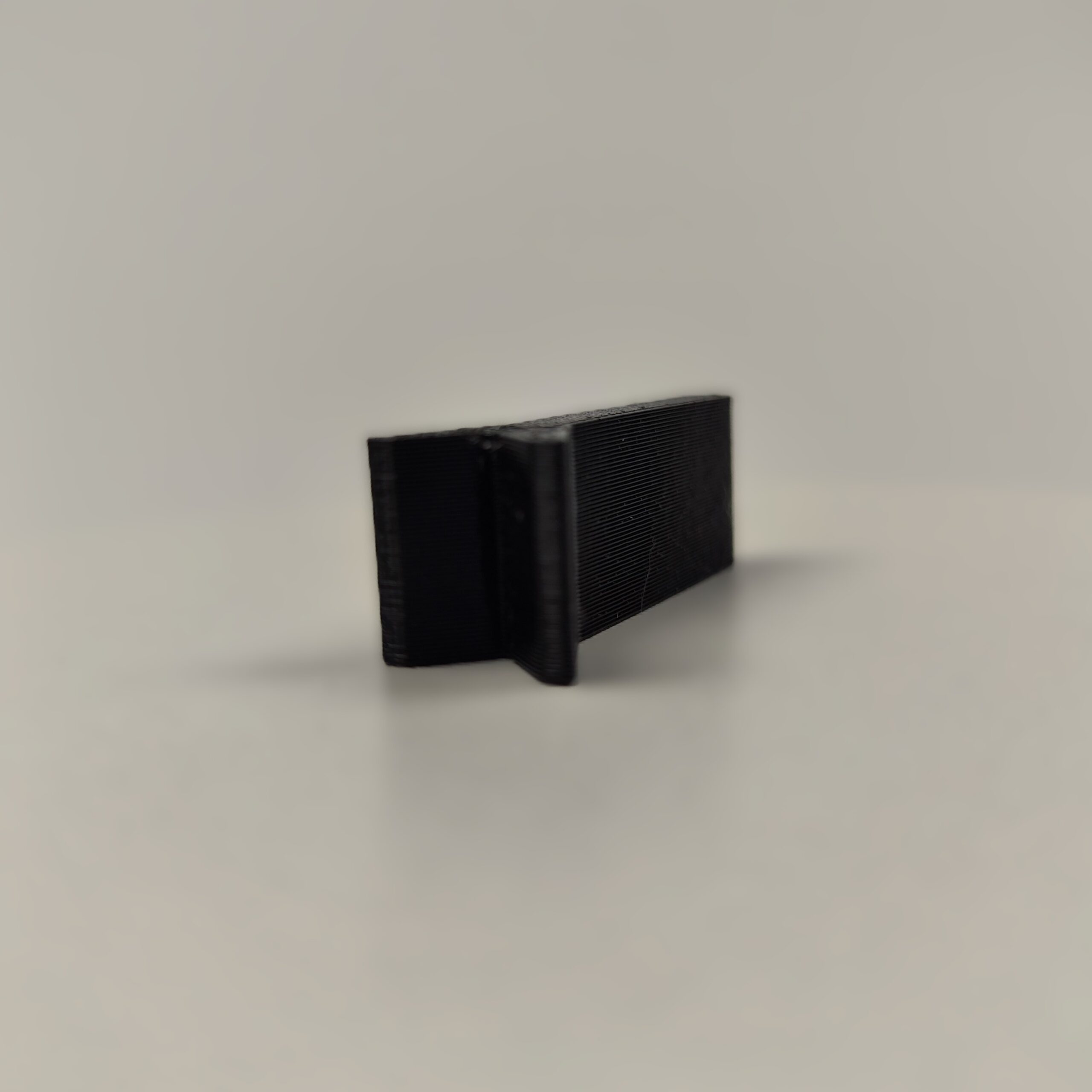 Magnetyczny uchwyt do gwoździ wykonany w technologii druku 3D z czarnego tworzywa, ułatwiający precyzyjne wbicie gwoździa bez narażania palców. Akcesorium ma formę płaskiego elementu z widocznym okrągłym zagłębieniem na magnes i szczeliną stabilizującą gwóźdź