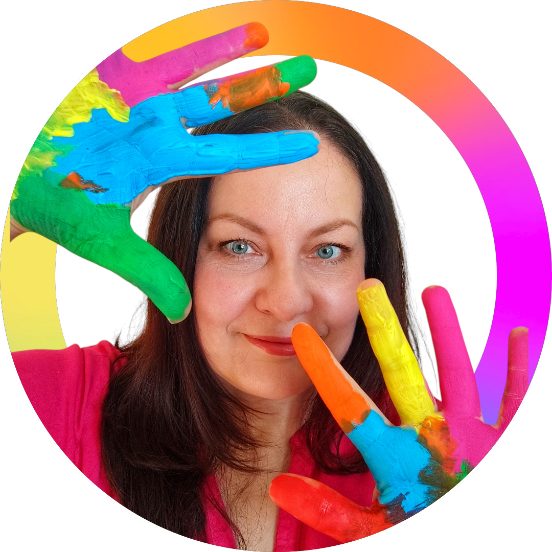 Kobieta z długimi ciemnymi włosami trzyma przed twarzą dłonie pomalowane w intensywne kolory tęczy, na białym tle z okrągłą ramką w gradientowych barwach