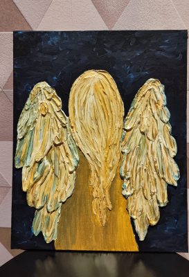 Obraz strukturalny „Anioł” wykonany z gładzi na czarnym płótnie – złota sylwetka z długimi włosami i reliefowymi skrzydłami w odcieniach złota i zieleni na tle geometrycznych dekoracji ściennych